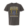 College-aged male wearing the fraternity Collegiate Crest Graphic Tee in charcoal grey, featuring vintage Alpha Epsilon Pi crest artwork on campus.